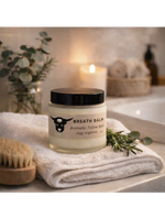 Jar of breath balm on a towel with a candle and plant in the background
