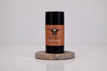 Deodorant stick with brown label and black cap on a white background