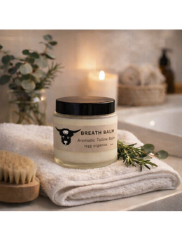 Jar of breath balm on a towel with a candle and plant in the background