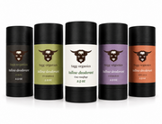 Five Tallow Organics deodorant sticks in different colors (black, olive green, white, purple, and orange) arranged in a row on a white background.