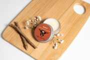 Balm tin with a label on a wooden board with twigs and flowers