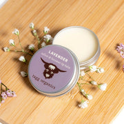 Lavender lip balm with packaging on a wooden board with flowers